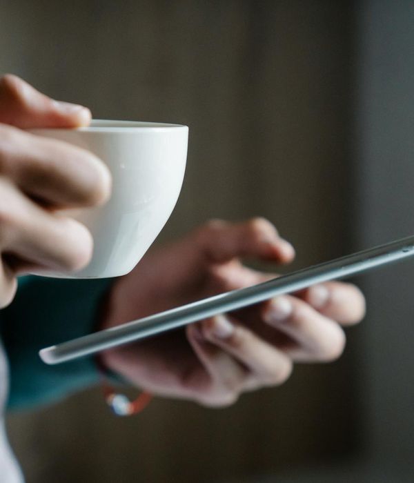 Person reading productivity newsletter on tablet with morning coffee