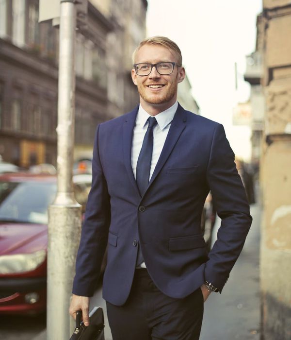 Professional man wearing glasses smiling confidently in casual business attire