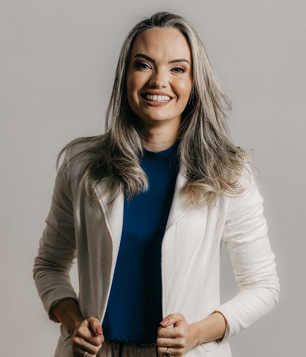 Professional woman with dark hair in elegant business outfit smiling warmly